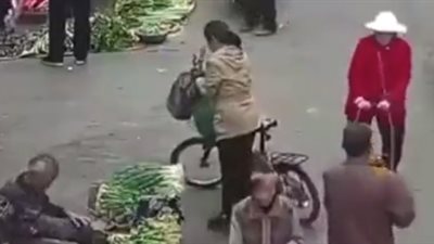 لص يسرق هاتف امرأة أمام المارة والبائعين في سوق شعبي (فيديو)