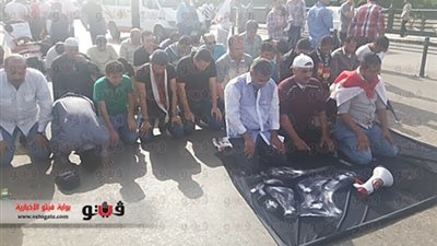 متظاهرو المنصورة يؤدون صلاه الظهر بالميدان وسط حراسة الأقباط