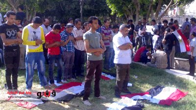 أقباط يحرسون المتظاهرين أثناء صلاة العصر بميدان الشهداء بالمنيا
