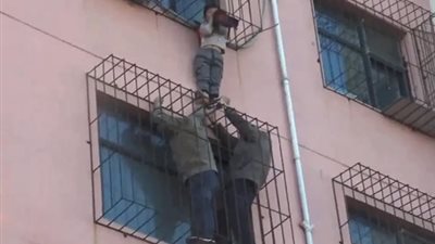 لحظة إنقاذ صبي انحشر بين سياج نافذة بالطابق الرابع (فيديو)