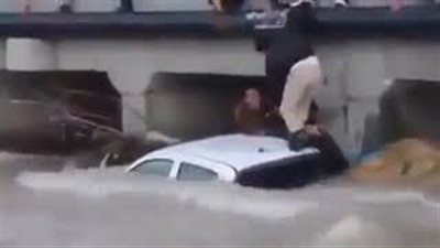 شاب يضحي بسيارته لإنقاذ أشخاص من مياه السيول (فيديو)