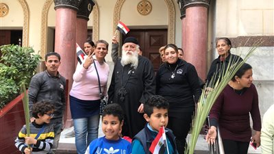 عاملو كنيسة مار جرجس ببورسعيد يرفعون الأعلام و«السعف» (صور)