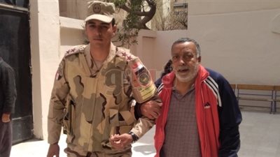 رجال الأمن يساعدون كبار السن أمام لجان الاستفتاء في الإسكندرية (صور)