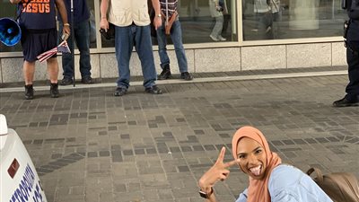 فتاة محجبة تلتقط صورا أمام متظاهرين مناهضين للإسلام تشعل الإنترنت