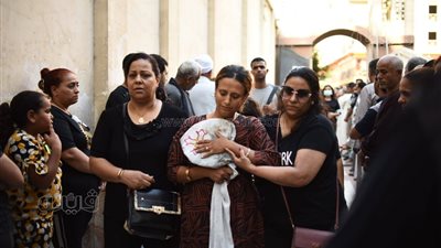 تحتضن ملابس الخدمة الكنسية.. زوجة القس عبد المسيح بخيت تصل لجنازته|صور 