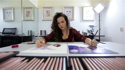بالفيديو.. فنانة ترسم 6 لوحات بيديها ورجليها في وقت واحد
