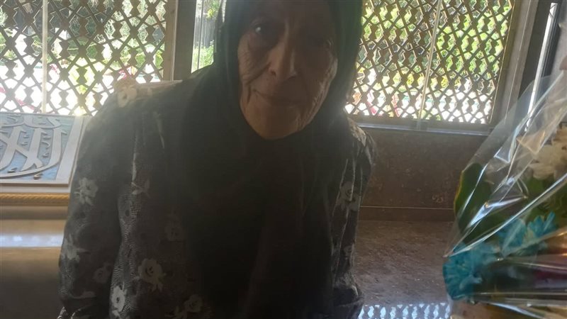 عجوز تبكى أمام ضريح