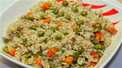 طريقة عمل الأرز بالبسلة والجزر.. أكلة مغذية لصغارك | فيديو