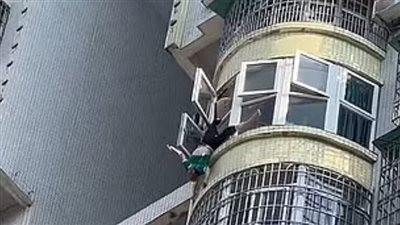 مسن صيني يحبس الأنفاس بعدما علق في نافذة مبنى شاهق | صور