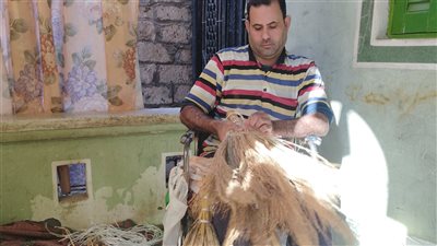 بعد إصابته بالعمود الفقري، عبد الرحمن يبدع في صناعة المكانس اليدوية بالبحيرة (فيديو)