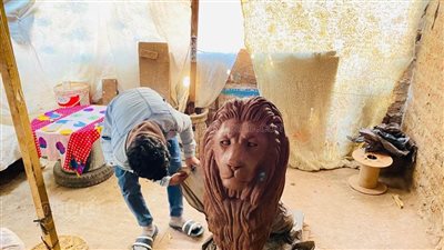 ورشته فوق سطح منزله.. طالب بخدمة اجتماعية في المنيا ينحت تمثالًا طبق الأصل من أسد قصر النيل (فيديو وصور)