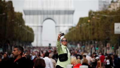 رغم أزمة الغواصات النووية.. الحشود تتدفق على شارع الشانزليزية بفرنسا| صور 