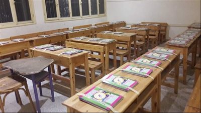 مدير مدرسة يوزع الكتب على ديسكات الطلاب استعدادًا لبدء العام الدراسي 