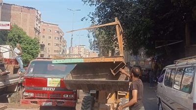 رفع تعديات الباعة على الطريق العام والسيارات المتهالكة في حي الوراق (صور)