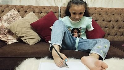 إيدي عند ربنا ونفسي أكون طبيبة.. قصة الطفلة جنة المولودة بدون ذراعين وتنجز مهامها بقدميها (صور)