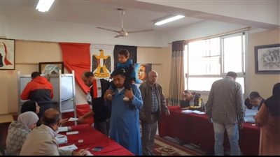 مواطن يحمل حفيده أثناء إدلائه بصوته في الانتخابات الرئاسية بالغربية (فيديو)
