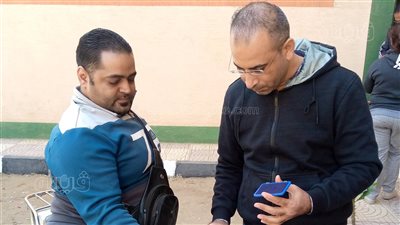 مساعدة ناخب من ذوي الهمم على التصويت خارج اللجنة (صور)