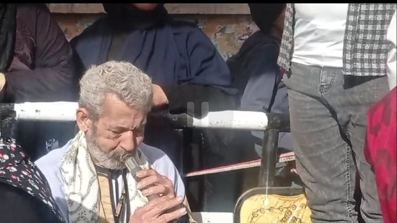 رجل مسن يعزف المزمار