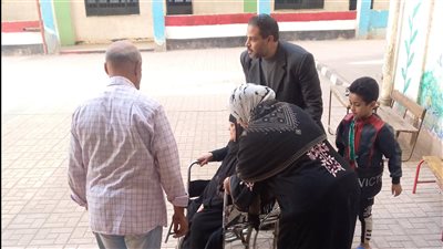 رئيس لجنة انتخابية في شبرا الخيمة يستعين بكرسي متحرك لمساعدة المسنين (صور)