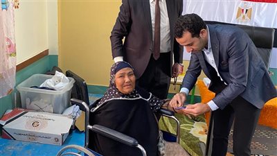 قاض يساعد مسنة للإدلاء بصوتها الانتخابي في زفتى (صور)