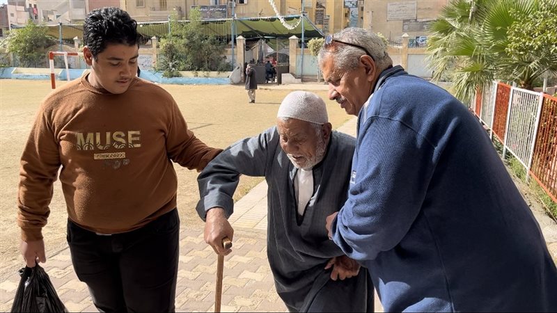 عجوز يدلي بصوته بمساندة