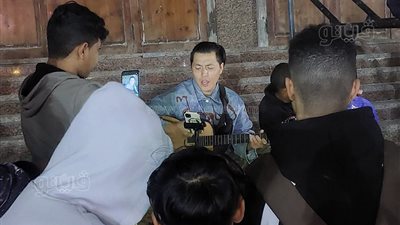 شاب ذو ملامح آسيوية يغني ويعزف الجيتار على كورنيش مطروح (صور)