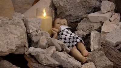 طفل بالكوفية الفلسطينية بين الركام بديًلا لشجرة الكريسماس، بيت لحم تحيي عيد الميلاد دون احتفالات والهدايا رسائل تعزية