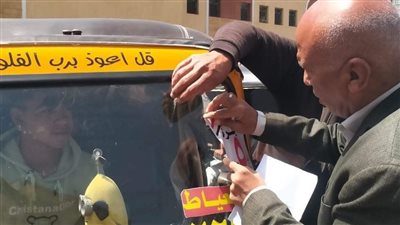 رئيس مدينة العياط يلصق بوستر بقيمة الأجرة على مركبات التوك توك (صور)