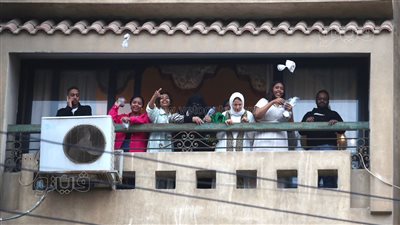 فرحة العيد جمعتنا، من البلكونة أسرة سودانية توزع الهدايا على المصلين بمصر الجديدة (صور)