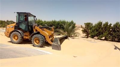 معدات ثقيلة لإزالة زحف الرمال على طرق واحة الخارجة بالوادي الجديد (صور)