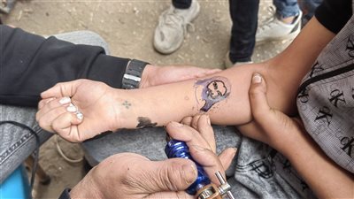 الصليب بـ 50 جنيها وصورة القديسين بـ 1000، أسعار الوشم في احتفالات أحد السعف بأسيوط (فيديو وصور) 