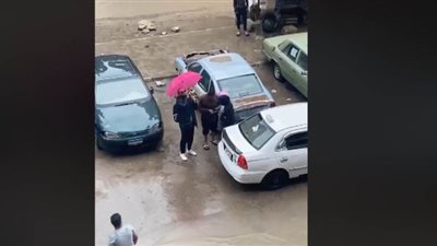 شاب يتحدى الطقس السيء ويعزف لخطيبته أمام منزلها | فيديو