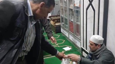 إبداعات المصريين وقت الأزمة.. مواطن يوزع قطع قماش على المصلين لمنع انتشار كورونا