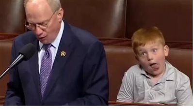طفل الكونجرس يخطف الأنظار بسبب حركات وجهه أثناء حديث والده بالبرلمان (فيديو)
