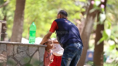 المظلات والمياه المثلجة، حيلة زوار حديقة الأسماك للهروب من الحر (صور)