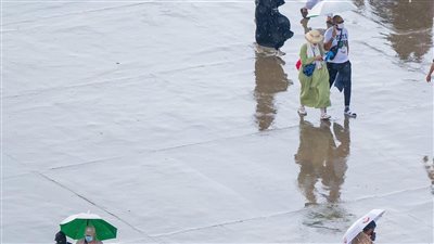 مشاهد مبهجة لضيوف الرحمن تحت الأمطار الغزيرة (صور)