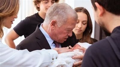 الملك عبدالله الثاني وأفراد العائلة المالكة يحملون ابنة الأمير الحسين (صور)