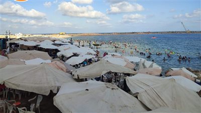إقبال متوسط على شواطئ الإسكندرية ورفع الرايات الخضراء والصفراء 