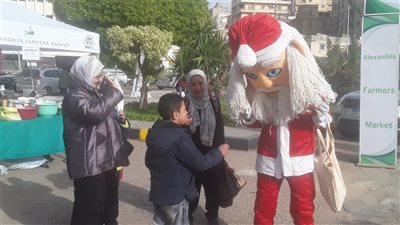 بابا نويل يوزع الهدايا والبالونات الملونة على الأطفال بسوق المزارعين في الإسكندرية 