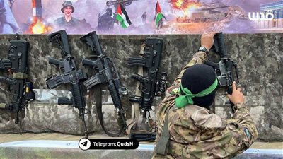 حماس تضع أسلحة اغتنمتها المقاومة خلال طوفان الأقصى على منصة تسليم الأسرى