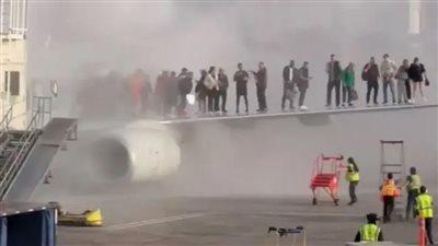 اشتعال النيران فجأة في طائرة أمريكية والركاب يفرون باستخدام جناحها (فيديو)