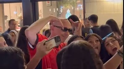 بقميص المنتخب المصري، آدم بورت يتجول بشوارع القاهرة ويلعب الطاولة على المقاهي (صور)