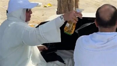 وجعلنا بينكم مودة ورحمة، زوجة تخفف حرارة الجو على زوجها في عرفات (فيديو) 