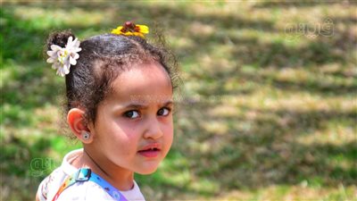 أثناء فسحة العيد، طفلة تزين شعرها بالورود داخل حديقة الأزهر (صور) 