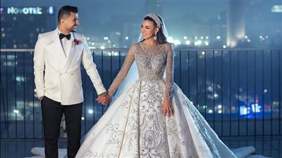 مرصع بالألماس.. اليوتيوبر علي غزلان يثير الجدل بفستان زفاف زوجته | صور