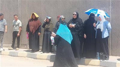 بالشماسي، أولياء أمور طلاب الثانوية العامة يحتمون من الشمس أمام اللجان بالدقهلية (صور)