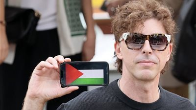 على هاتفه، ميشيل ريوندينو يرفع علم فلسطين لحظة وصوله مهرجان فينيسيا (صور)