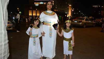مهندسة وطفلاها بالزي الفرعوني يخطفون الأنظار أمام شاشات عرض الاحتفال بافتتاح المتحف الكبير (فيديو وصور)
