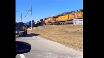 مقطع مروع، شاهد لحظة اصطدام قطار بشاحنة تحمل سيارات جديدة 