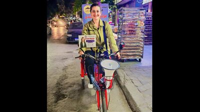 بالعجلة والميكرفون، مرشحة مجلس نواب تبتكر دعاية جديدة لانتخابها (فيديو) 